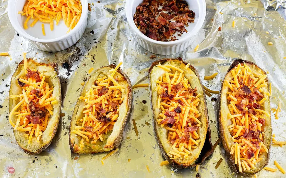 uncooked potato halves with cheese and bacon