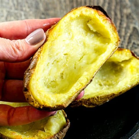 hand holding a plain crispy baked potato skin