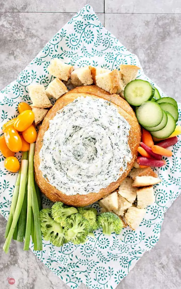 spinach dip in a bread bowl with veggies