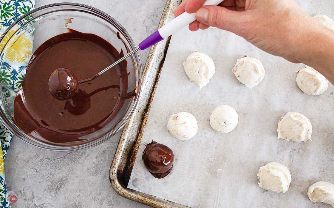 bourbon balls being dipped in melted chocolate