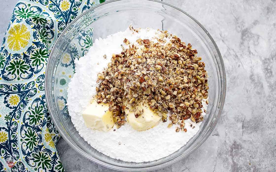 powdered sugar, butter, and pecans in a bowl