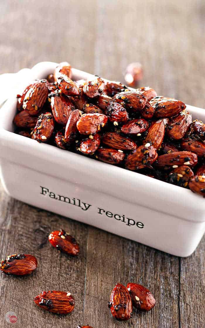 overhead picture of glazed almonds in a rectangle white dish