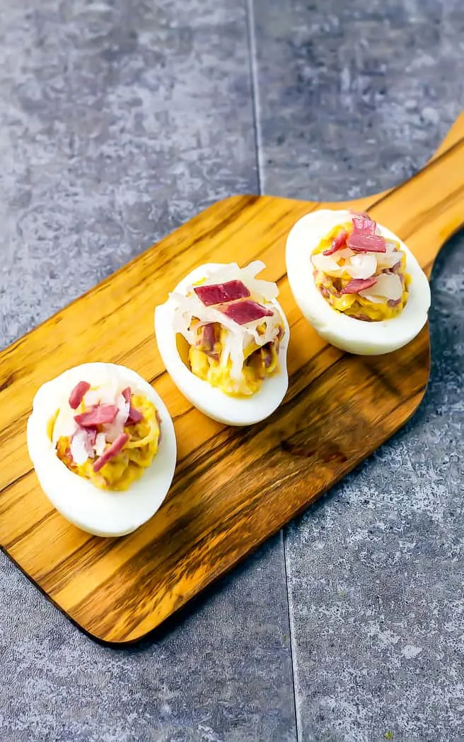 wood tray with three Reuben Deviled Eggs