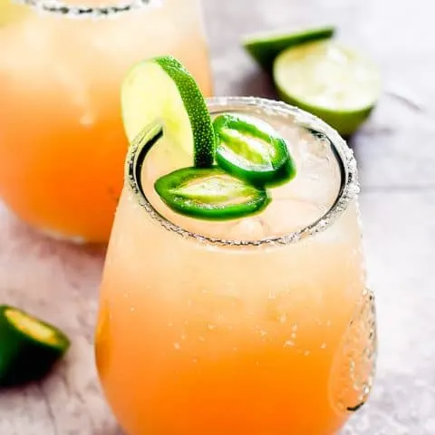 two glasses with cocktail and lime garnish