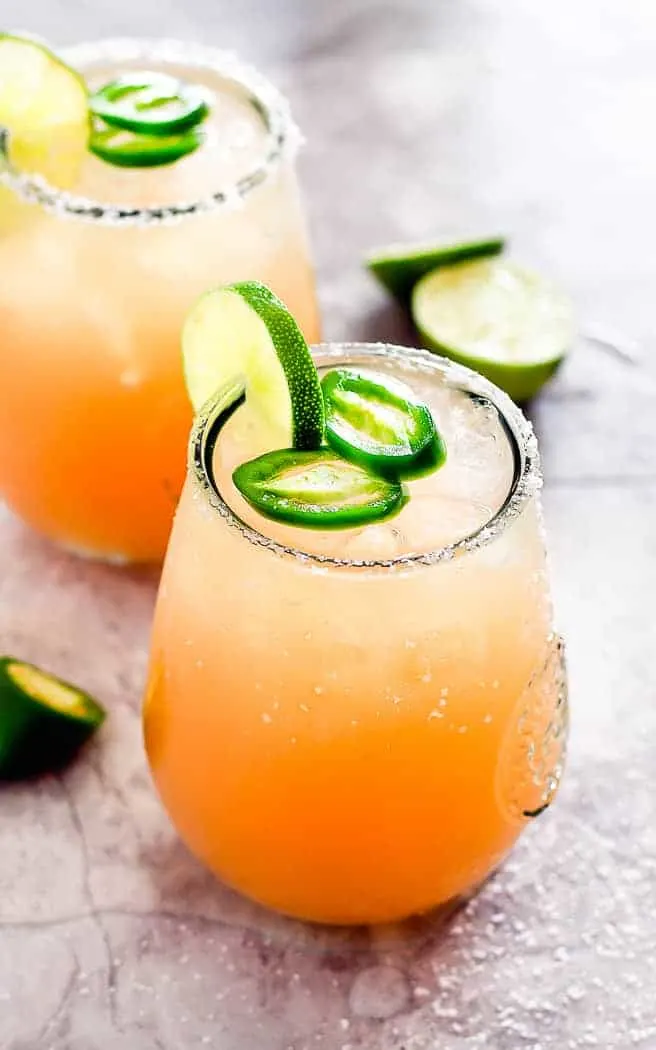 two glasses with cocktail and lime garnish