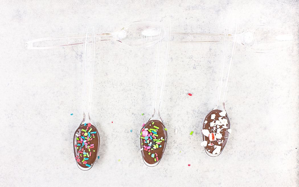 plastic spoons filled with chocolate and sprinkles