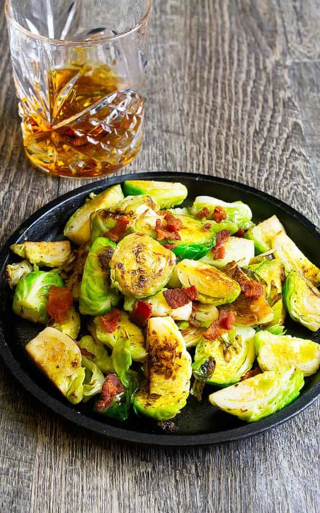 cooked sprouts with bacon on black plate