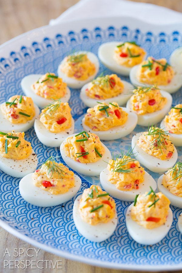 pimento cheese deviled eggs on a blue and white platter