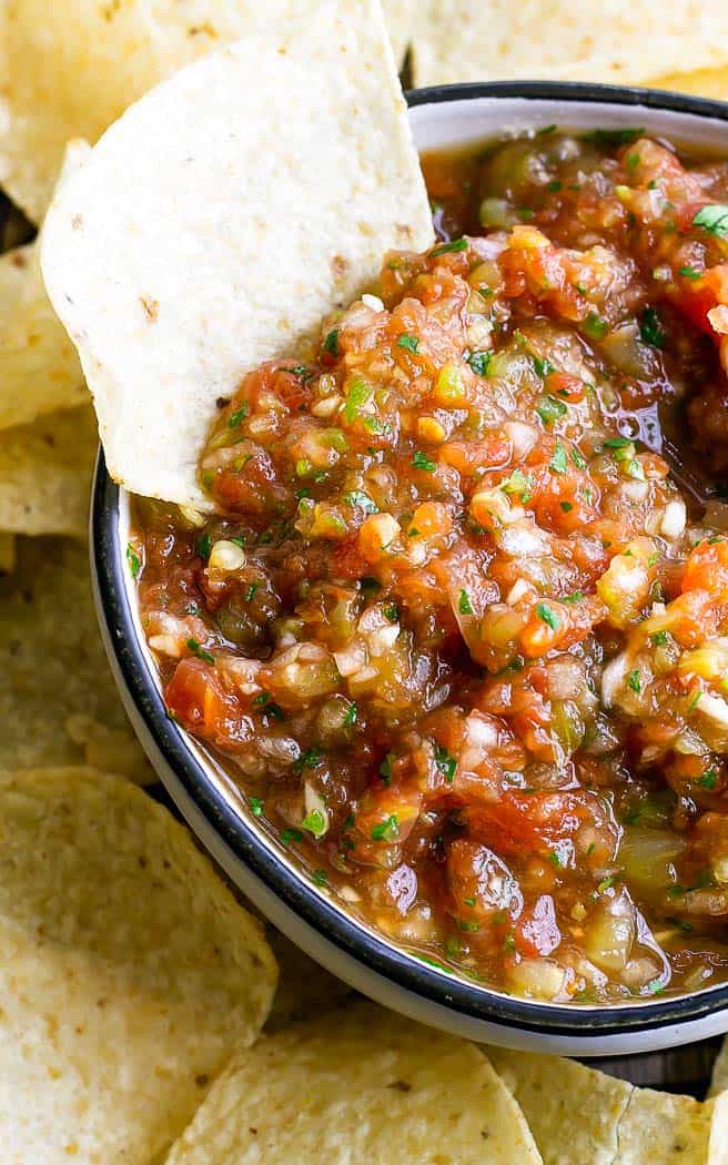 scooping salsa out of a bowl with a chip