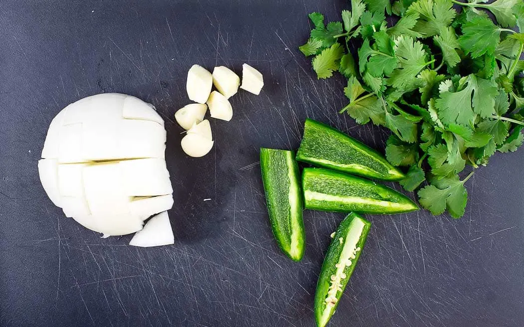 jalapeno, garlic, onion, and cilantro on a board