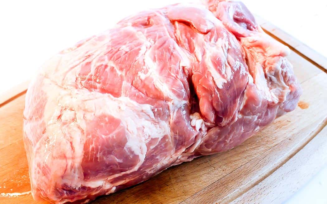 raw pork shoulder on a cutting board