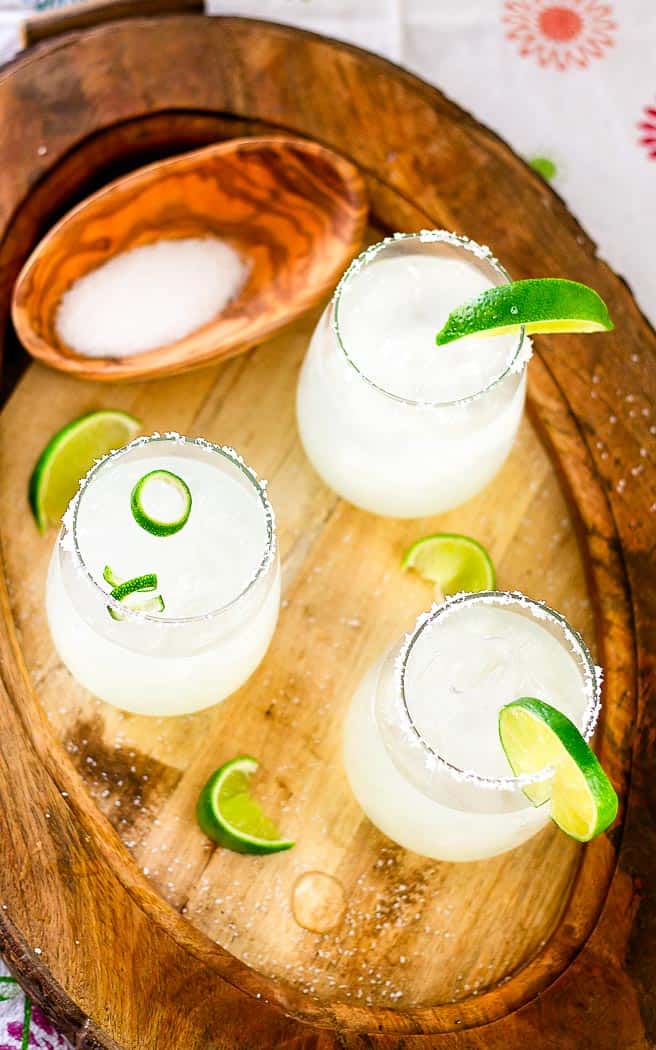 Overhead of three 3-ingredient limeade Margarita's on a wood serving tray