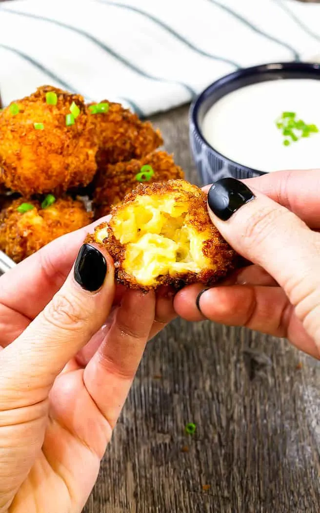 two hands pulling apart a friend mac and cheese ball