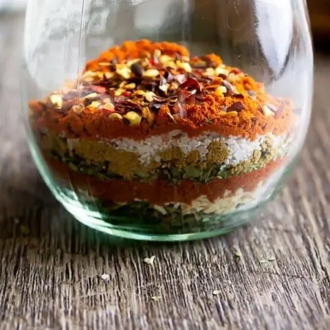 southwest seasoning layered in a glass jar on a wood plank