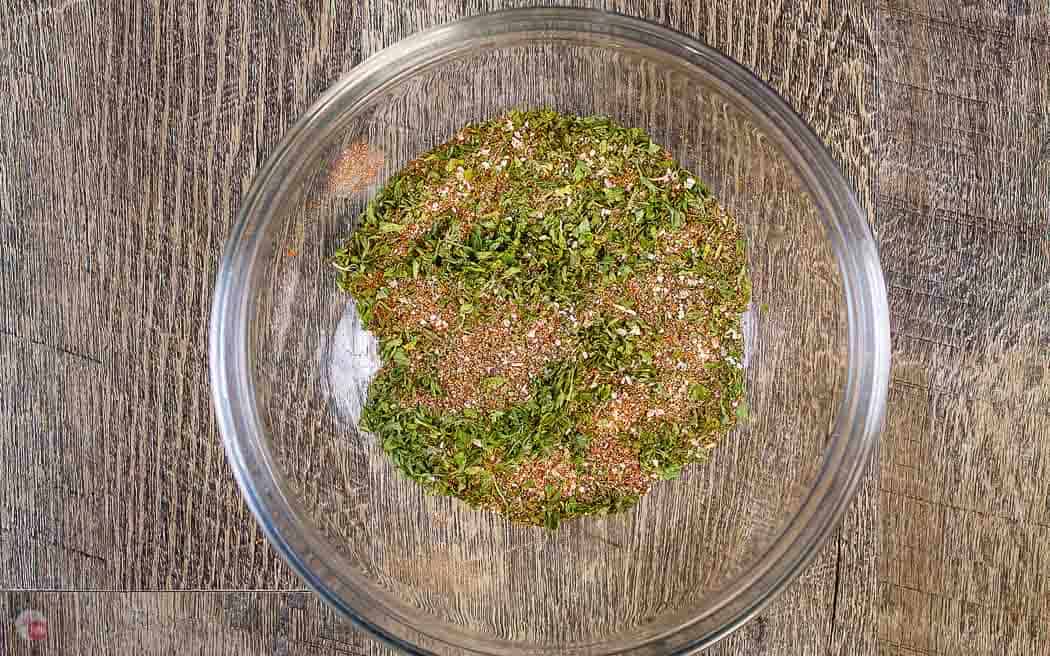 clear bowl of mixed spices on a wood background