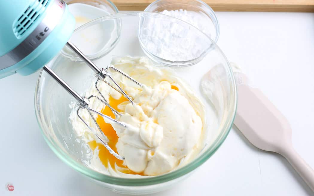 whipped cream cheese, yogurt, and juice in a clear bowl