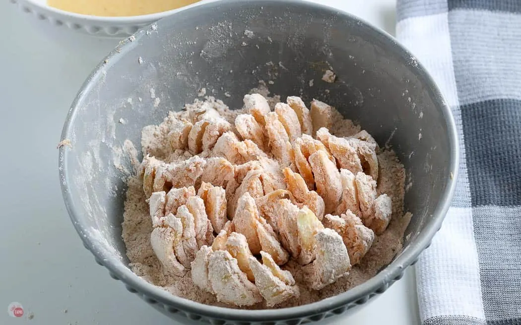 onion dredged in flour in a bowl