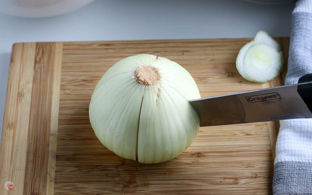 knife cutting down a whole onion