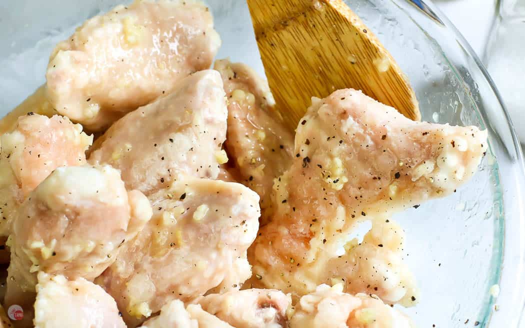 raw wings with garlic and spices in a clear bowl