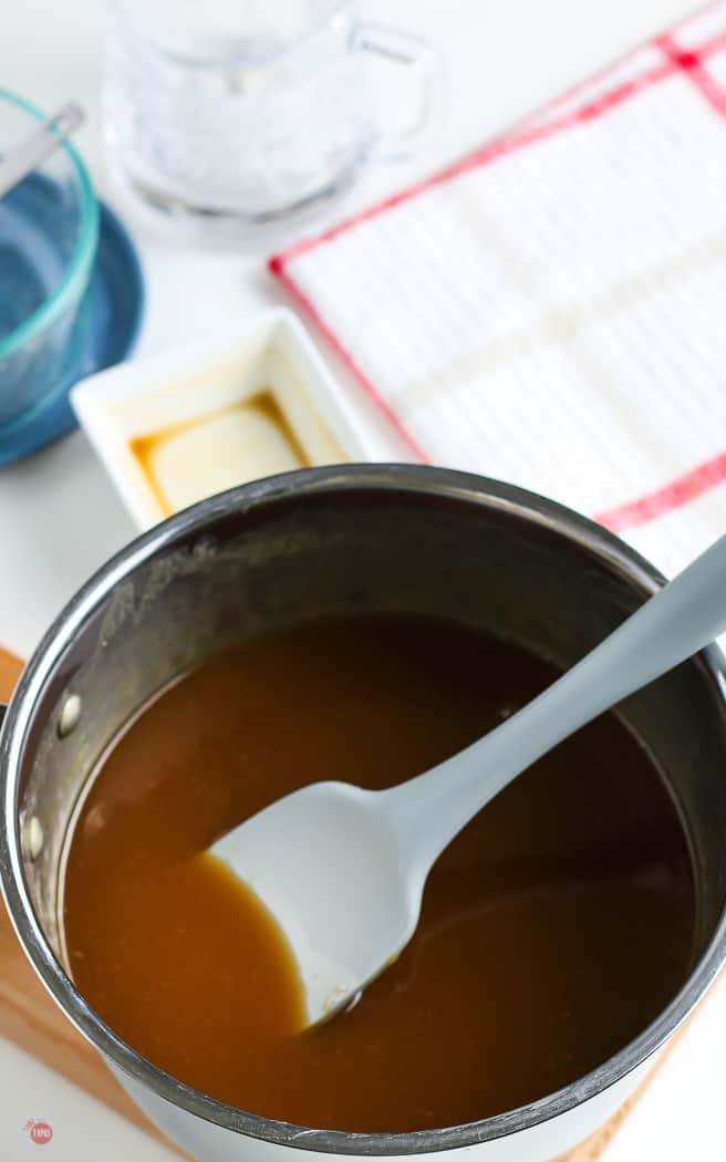 salted caramel sauce in a pot with a blue spatula