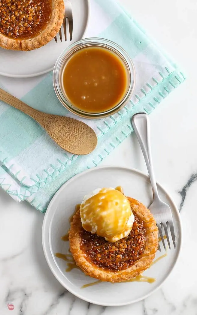 overhead picture of mini pecan pie with a jar of caramel sauce