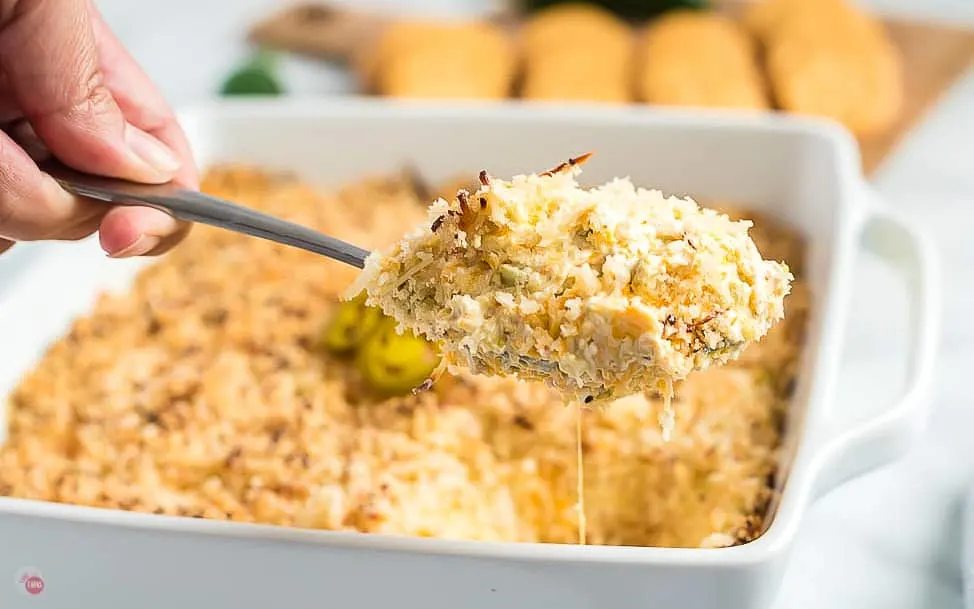 big scoop with scoop of dip above a dish of dip