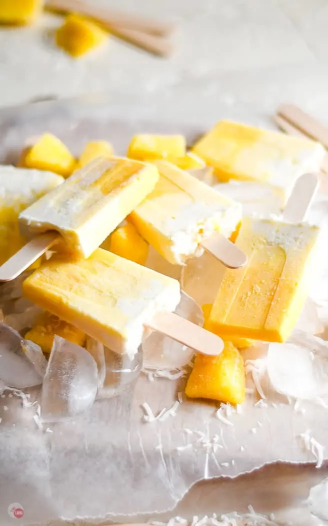 pile of popsicles on parchment paper topped with ice cubes