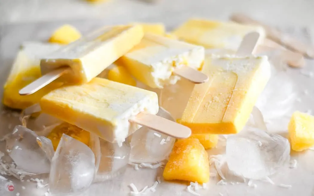 side view of obmre colored popsicles on a bed of ice cubes