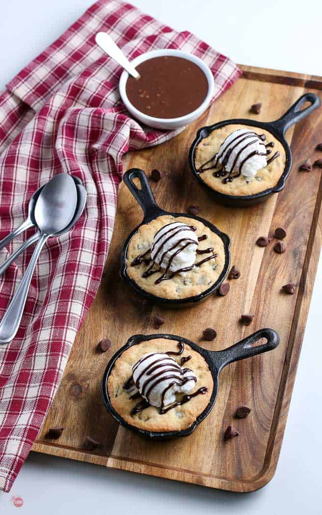 overhead picture of three skillet cookies on a wood cutting board