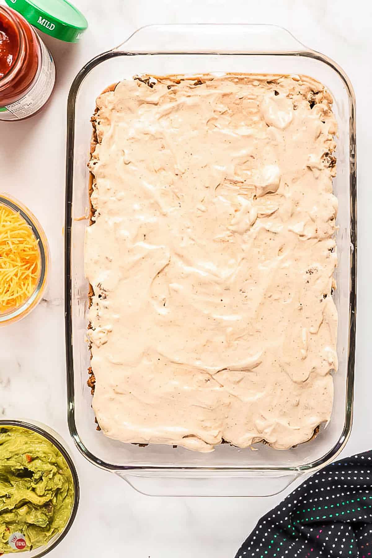 sour cream layered in a clear dish with spatula