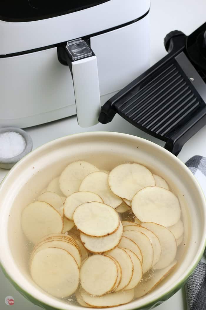 potato slices in a bowl of water