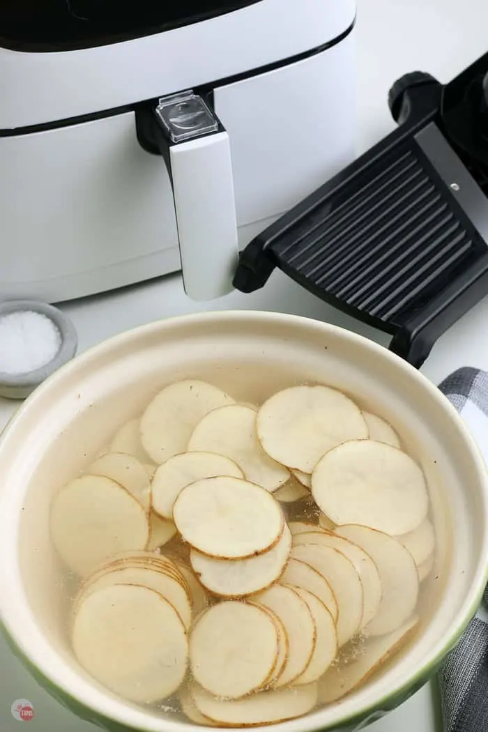 potato slices in a bowl of water