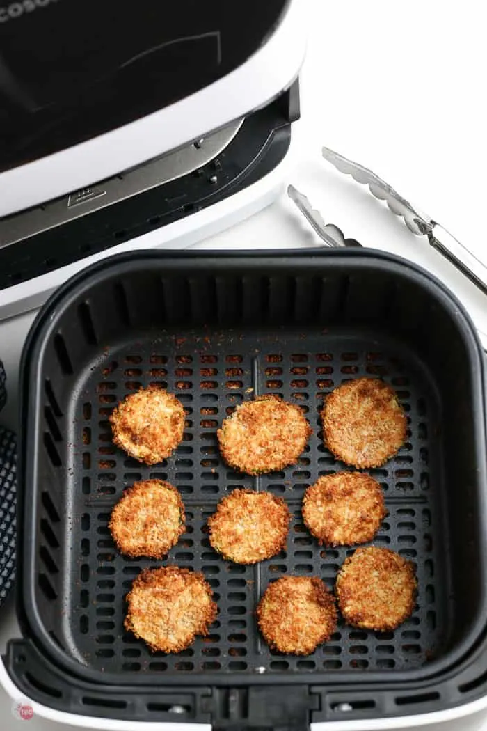 cooked breaded zucchini slices in air fryer basket