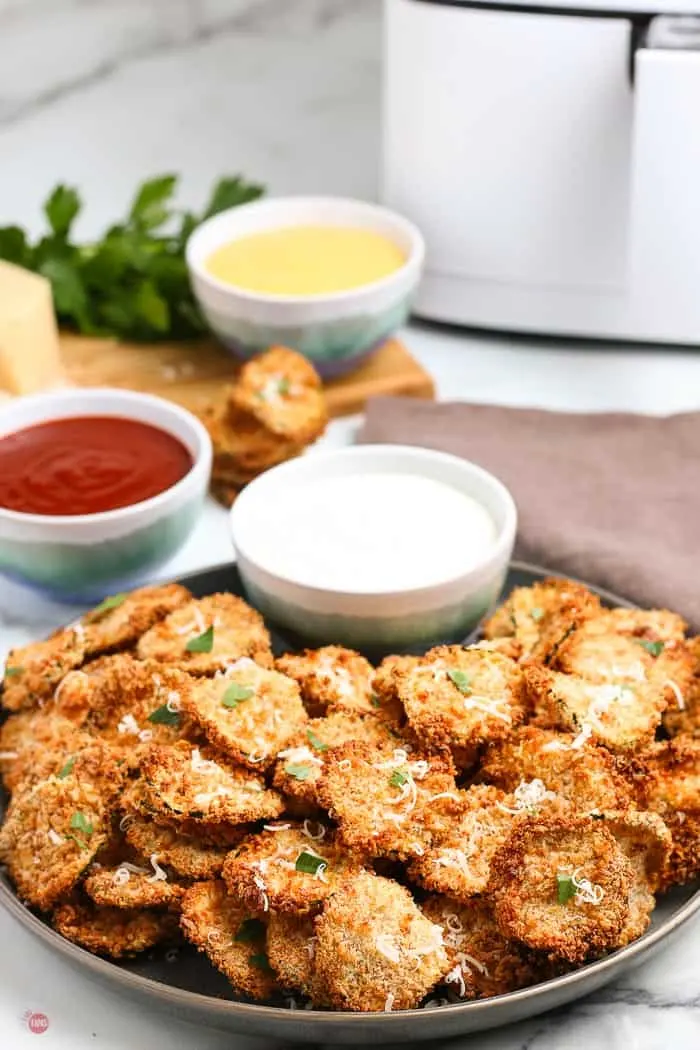 side view of air fried zucchini chips with dips