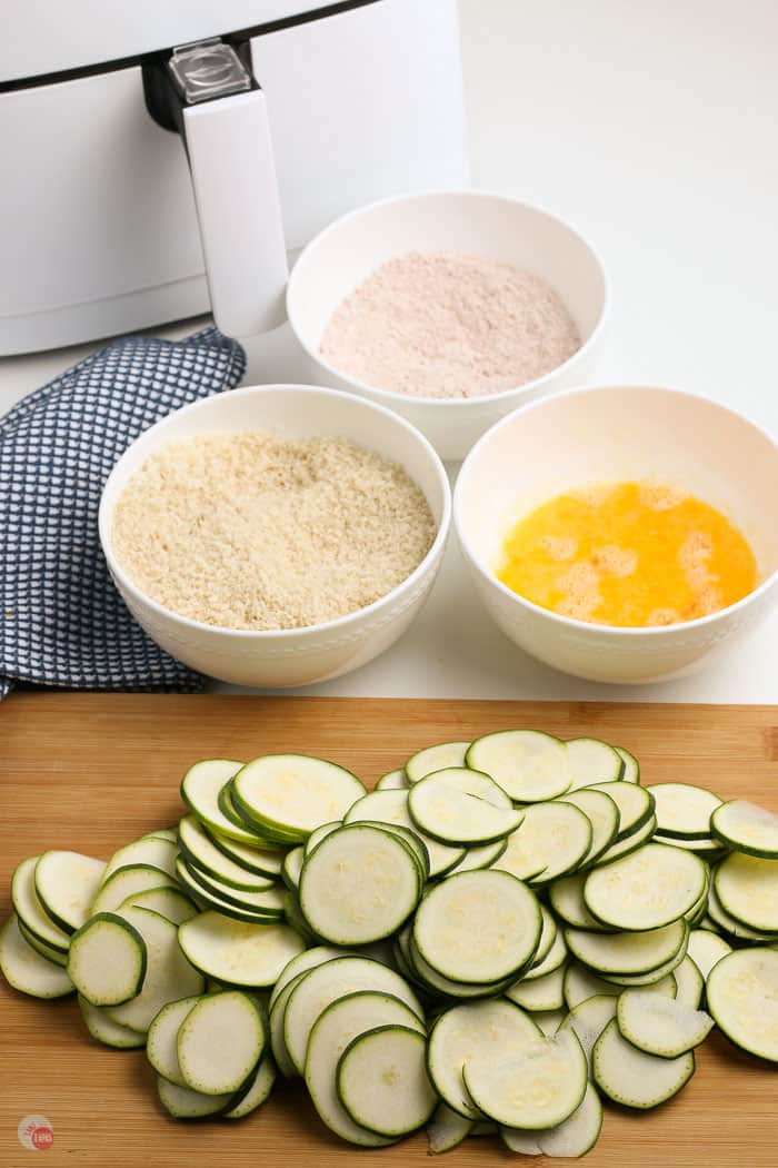 zucchini slices with three bowls of breading