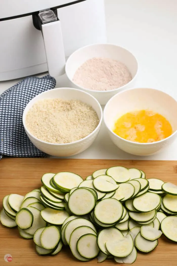 zucchini slices with three bowls of breading
