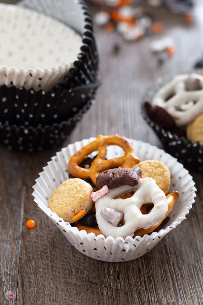 close up of halloween snack mix in a white muffin liner