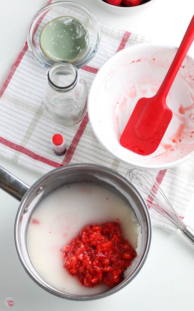 pot with sugar and strawberries with a red spatula