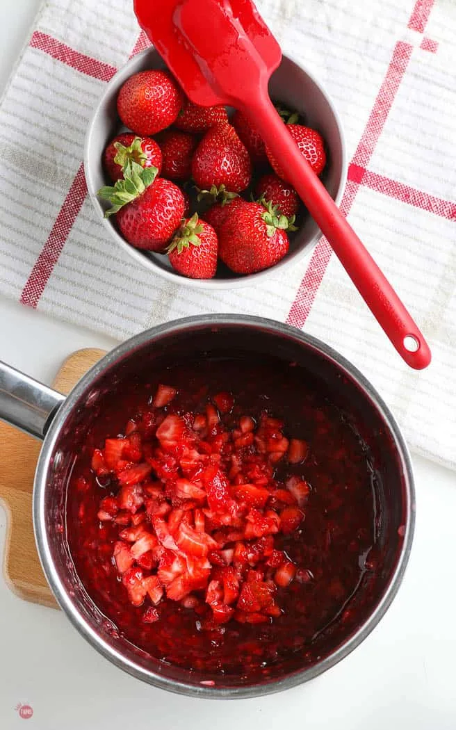 fresh strawberries in a pot of sauce