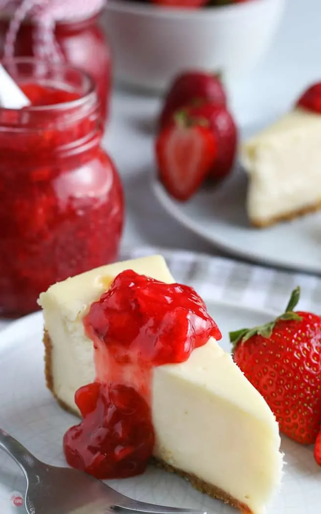 slice of cheesecake with strawberry sauce on a white plate