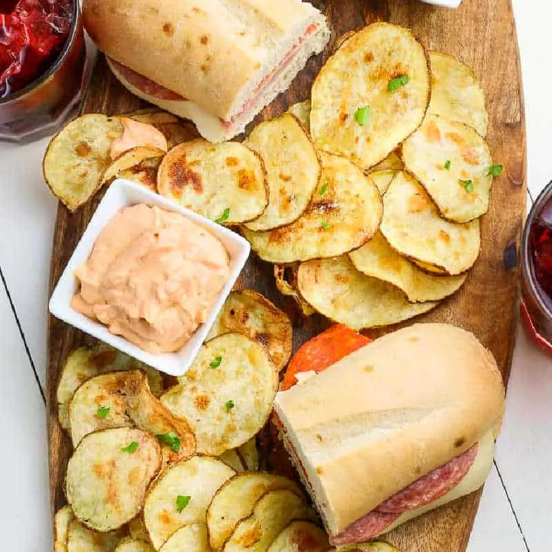 overhead picture of wood board with chips and sandwiches