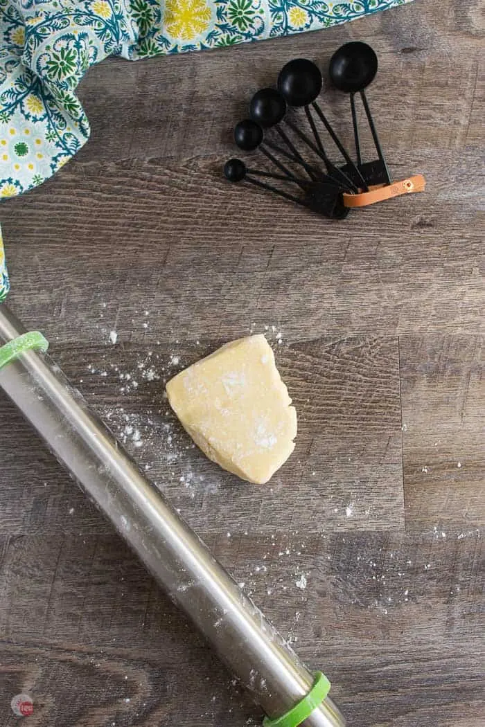 cookie dough and rolling pin on wood surface