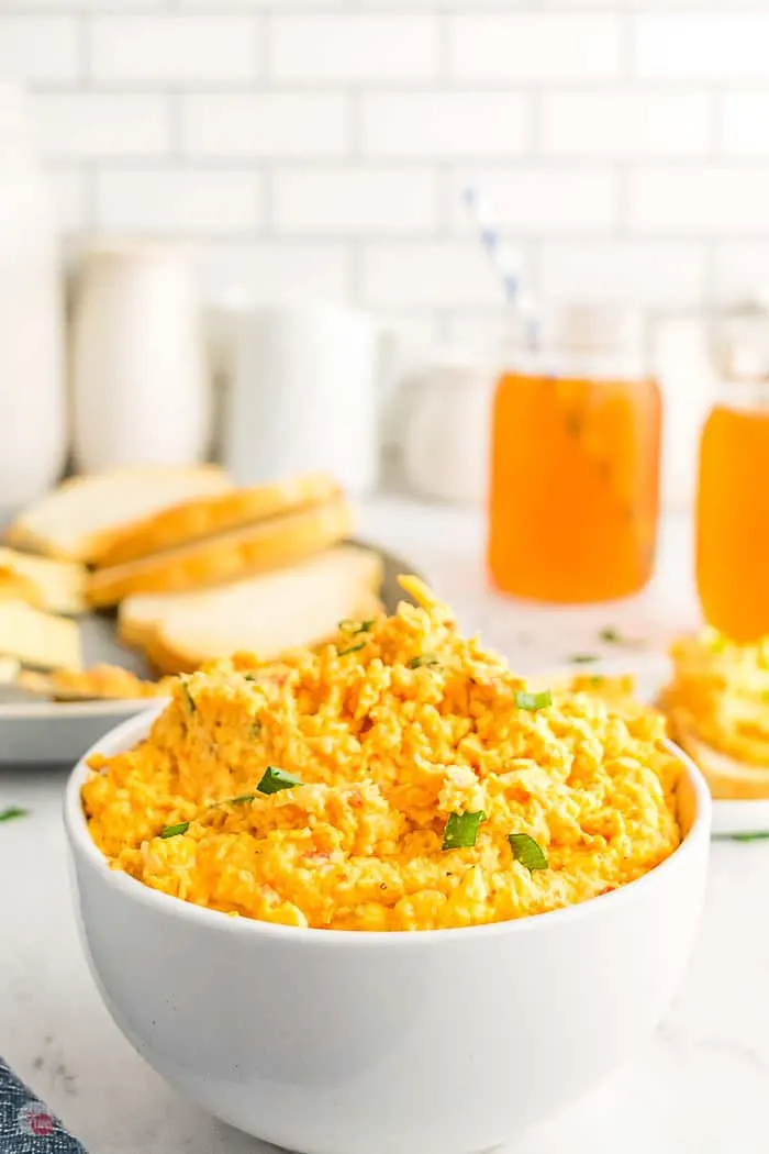 bowl of cheese spread with a plate of toast and two glasses of tea