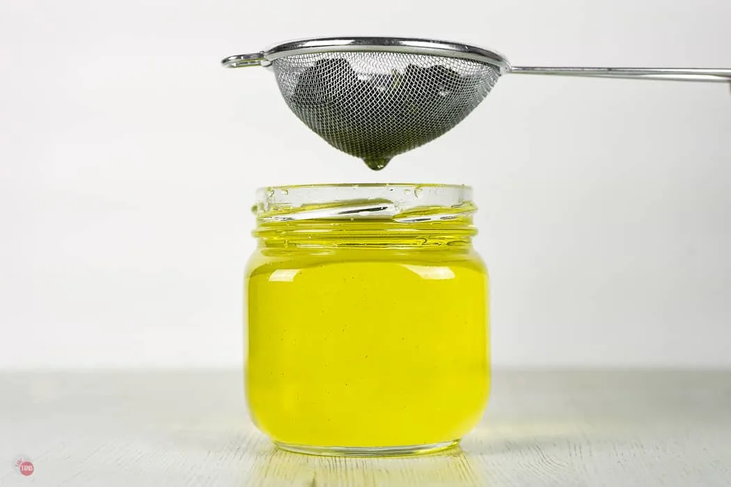 jar of yellow syrup with a sieve