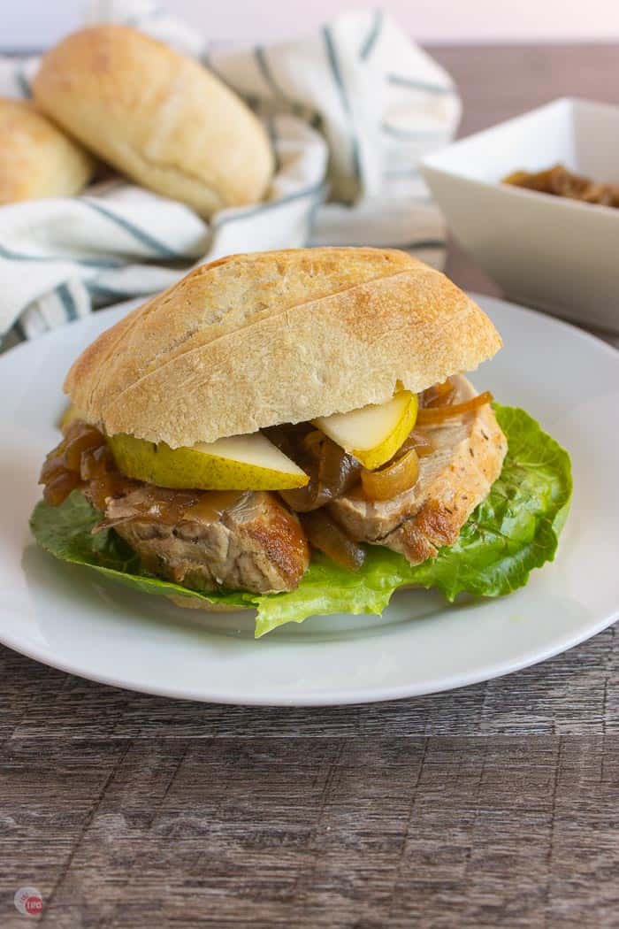 pork slider on a white plate with rolls in the background