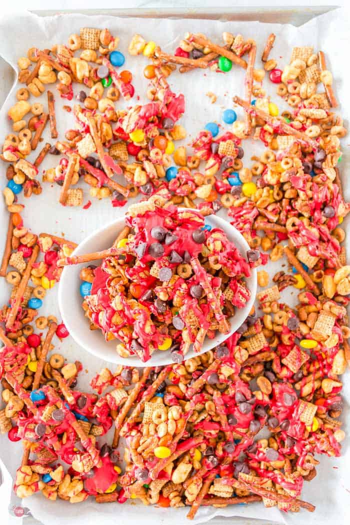 tray of elf christmas chex mix with a white bowl in middle