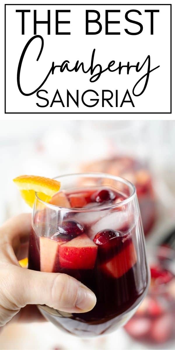 hand holding wine glass with text "the best cranberry sangria"