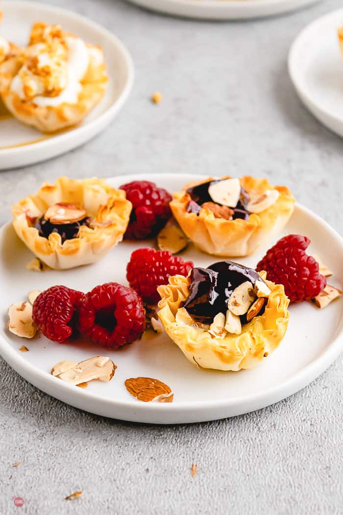 phyllo cups with raspberries on a white plate