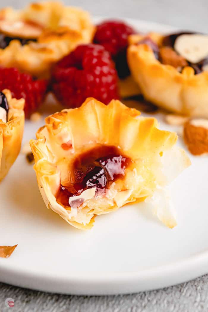 raspberry brie phyllo cup with bite removed on white plate