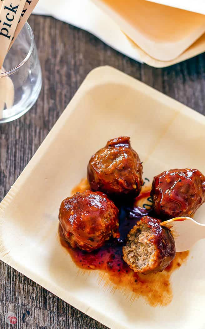 close up of meatballs on a plate with a bamboo fork